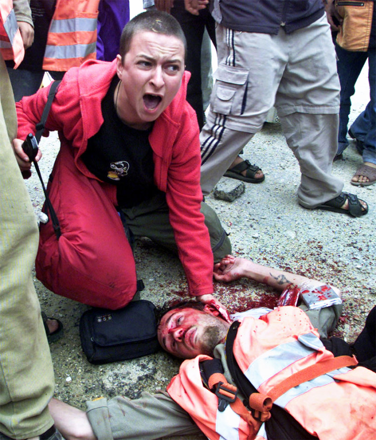 ** FILE ** A British peace activist going only by the name Alice cries for help as she holds her hand over the headwound of British peace activist Thomas Hurndall, who had been shot in the head moments earlier, at the start of a protest, in Rafah, southern Gaza Strip Friday, April 11, 2003. Hurndall died late Tuesday Jan. 13, 2004 at a hospital in London his family said Wednesday. (AP Photo/Khalil Hamra)