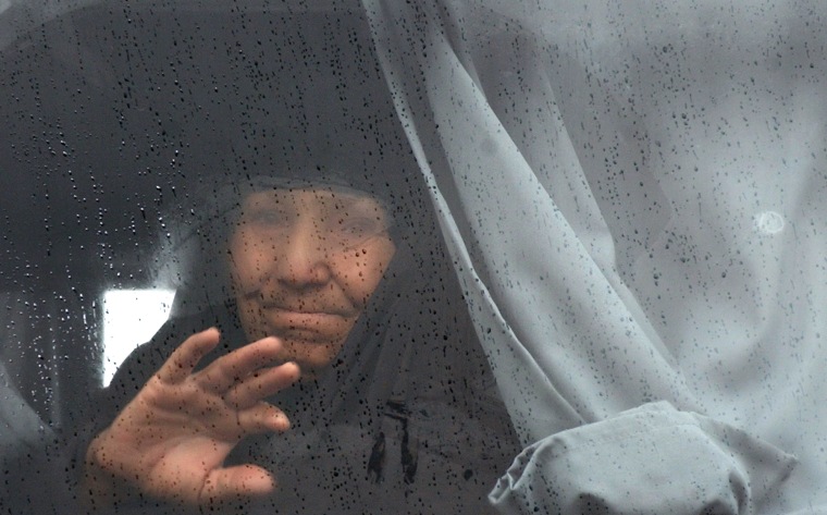 An elderly Iraqi woman waves to family members from behind a bus window Thursday as she leaves Baghdad on the hajj. The Muslim pilgrimage must be performed by any able-bodied Muslim that can afford it at least once in a lifetime.