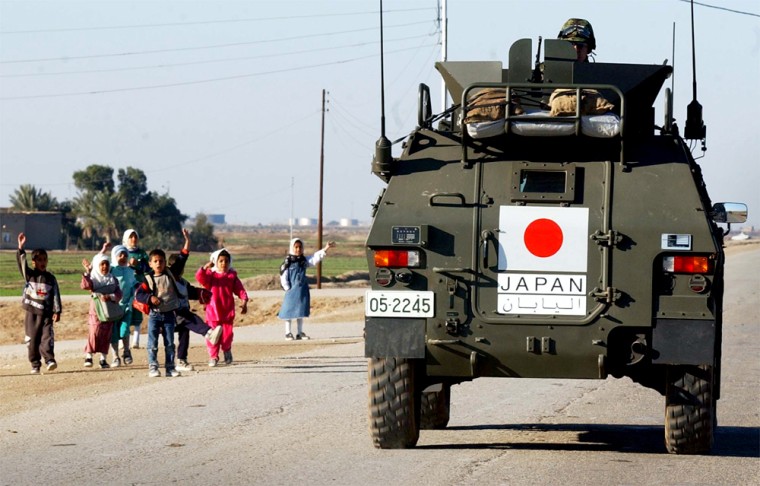 Japanese Army soldiers are cheered by Iraqi children as they leave their base in Samawa, southern Iraq, Tuesday, Jan. 20, 2004.  Japanese soldiers entered a conflict zone Monday for first time since World War II, crossing into Iraq on a humanitarian mission that has stirred controversy in Japan, while raising great expectations among Iraqis. (AP Photo/Gregorio Borgia)