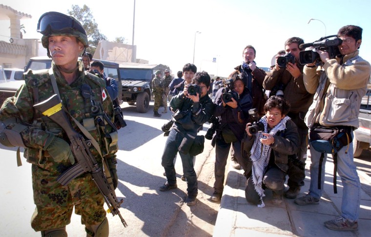 Japanese media surround a Japanese soldier during a visit to the city hall in Samawa, southern Iraq, on Tuesday.