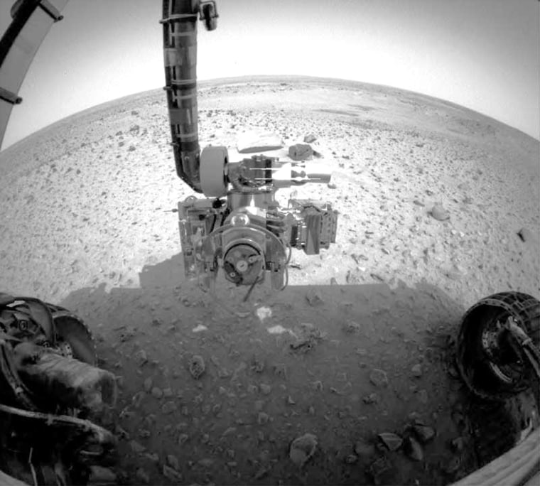 A picture taken by one of the Spirit rover's navigation cameras shows the robotic arm stretched out in front of the robot, bristling with scientific instruments and a rock-grinding tool.