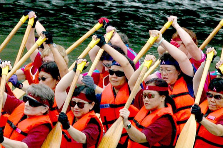 A dragon boat team made up of breast cancer survivors races down the river during the Singapore River Regatta.