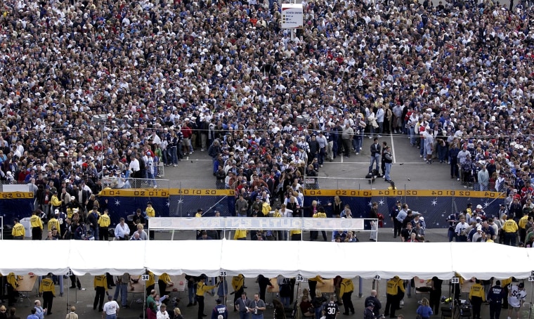 Fans line up outside the security fences to enter Reliant Stadium on Sunday for Super Bowl XXXVIII in Houston.
