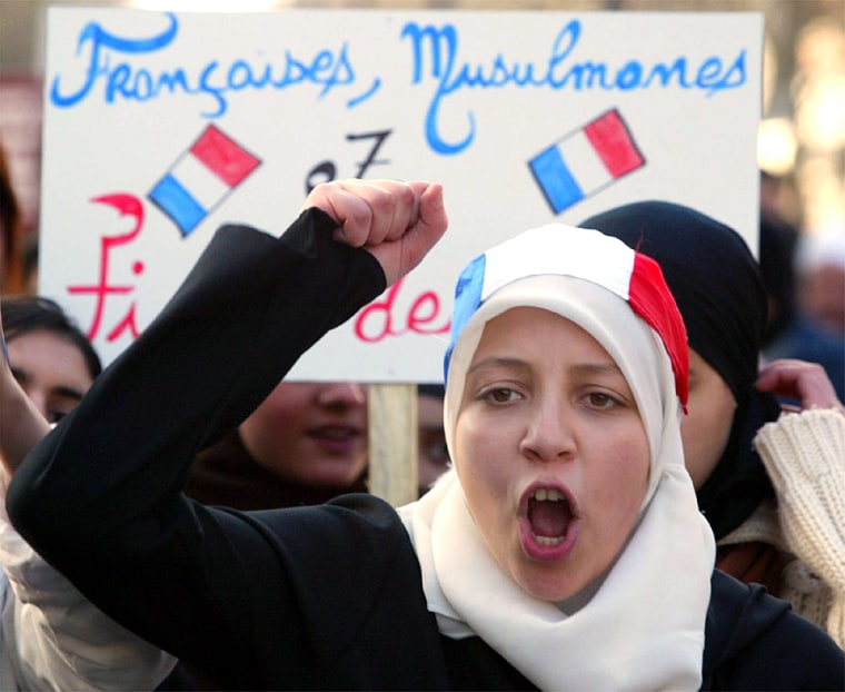 YOUNG MUSLIM WOMEN HOLDS FRENCH FLAG ON HER HEADSCARF DURING PROTEST IN LILLE