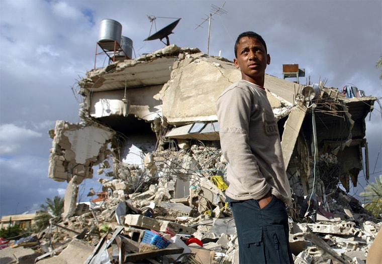 A Palestinian youth stands atop the rubble of at least three houses, demolished by Israeli forces during an operation to arrest militants, in the West Bank town of Jericho, at the start of the four-day Muslim holiday of Eid al-Adha, Sunday, Feb. 1, 2004. Israeli troops riding on jeeps and a tank raided the biblical town early Sunday for the first time in months, during a pinpoint operation to arrest fugitives who were planning an attack, according to the army, killing a Palestinian militant and woundingtwo others. The army also reported four arrests before pulling out of the town Sunday afternoon. (AP Photo/Lefteris Pitarakis)