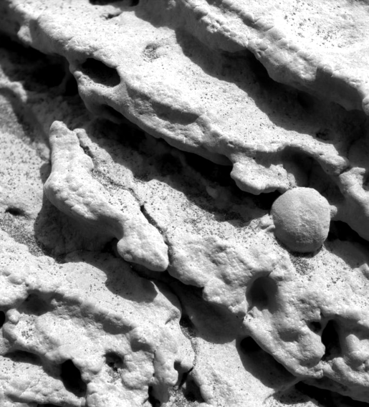 An extreme close-up of Martian bedrock, captured by the Opportunity rover's microscopic imager, shows ridges of rock and what appears to be a small pebble.