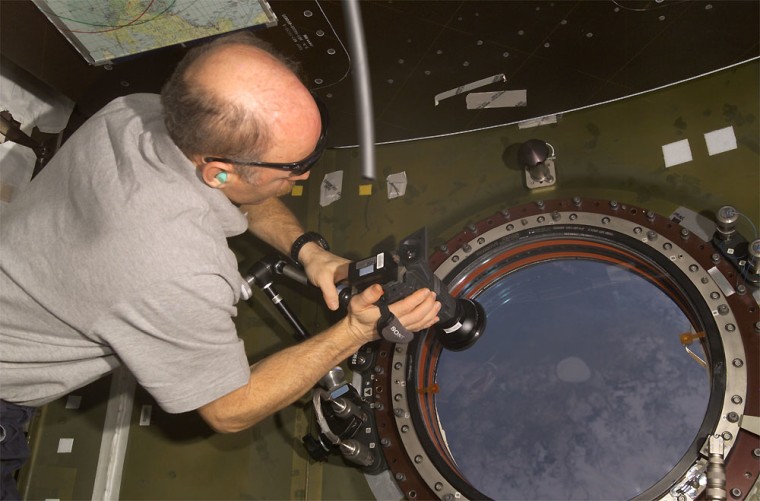 The U-shaped flex hose that was the source of the air leak can be seen in this file photo from the international space station, next to astronaut Ken Bowersox's right forearm.