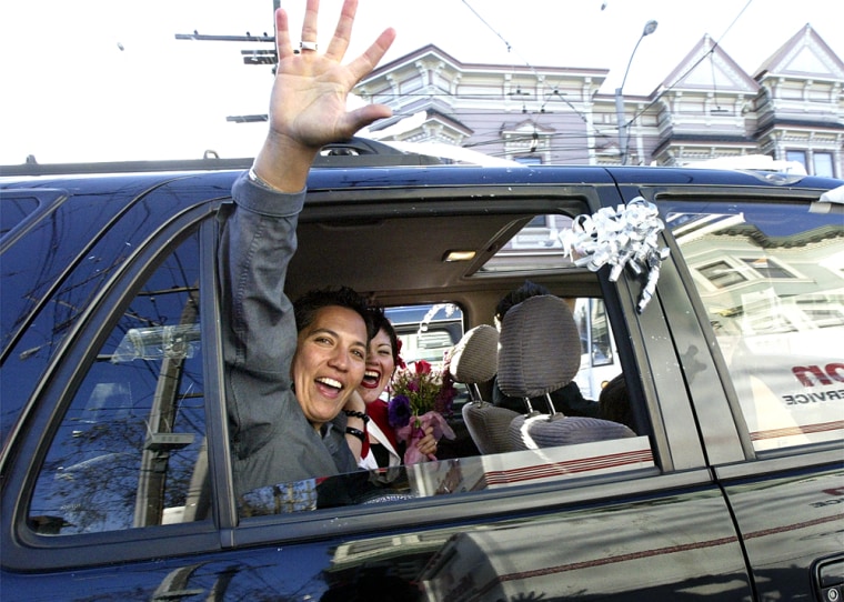 Newlywed Nancy Hodges waves to pedestrians as she and her partner, Zulma Reyes, are driven around the Castro district in San Francisco last week.