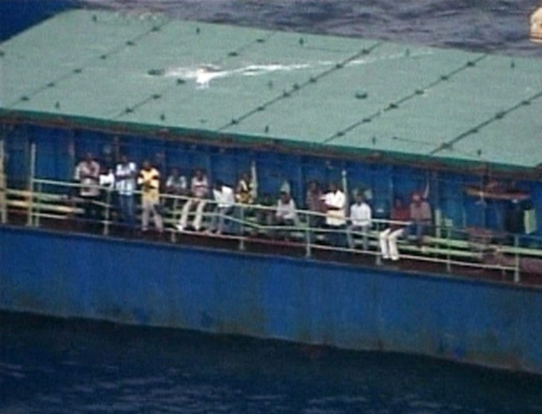 Haitians sit along the deck of a freighter Wednesday after being stopped by the U.S. Coast Guard off the coast of Florida.