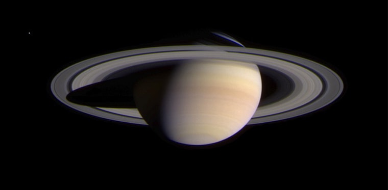 Saturn and its rings take center stage in the Cassini spacecraft's latest picture, snapped from 43.1 million miles away. The moon Enceladus is faintly visible in the upper left corner of the image.