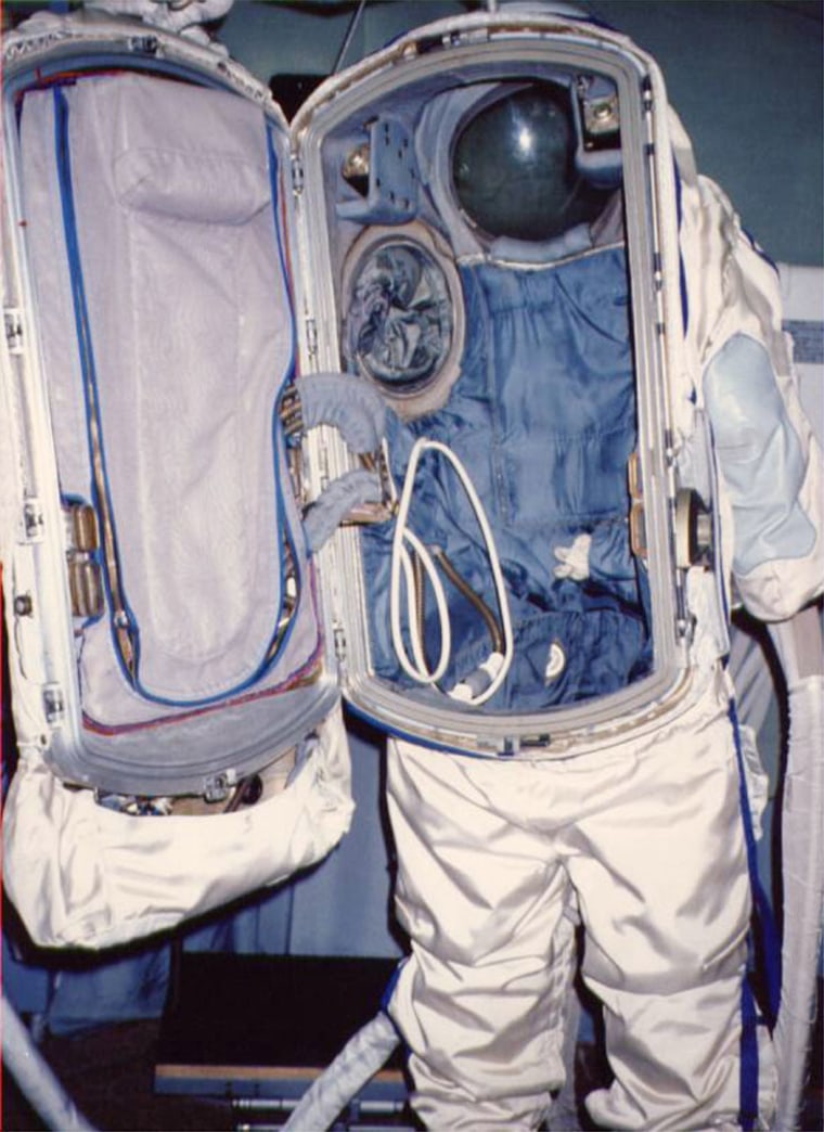 This Russian Orlan spacesuit opens in the back to reveal tubes and equipment. A spacewalker enters the suit through the back hatch.