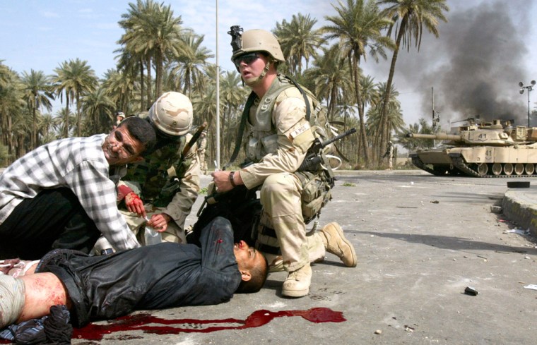 An injured Iraqi is treated after a stone-throwing mob -- blaming the United States for the deadly explosions -- attacked U.S. forces outside Camp Bonzai in Baghdad.