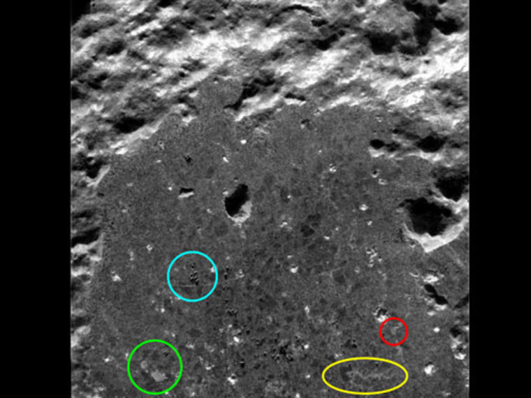 A microscopic image provided by the Spirit rover focuses on the rock known as Humphrey. The yellow and red circles highlight crystal-filled fissures that hint at interaction with water during the rock's formation. The blue and green circles highlight features that were probably created by the rover's scientific tools.