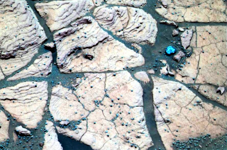 This false-color composite image, taken at a region of the rock outcrop dubbed "Shoemaker's Patio" near the Opportunity rover's landing site, shows finely layered sediments that have been accentuated by erosion. Spherelike grains or "blueberries" can be seen lining up with individual layers. This observation indicates that the spherules are geologic features called concretions, which form in pre-existing wet sediments.