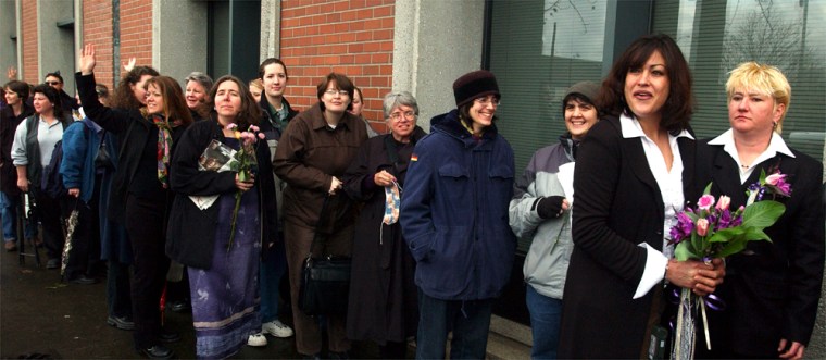Lesbian couples and their friends react to honks from passing motorists as they wait in line to apply for marriage licenses outside the Multnomah County Clerk’s Office in Portland, Ore., in this March 3 file photo. 