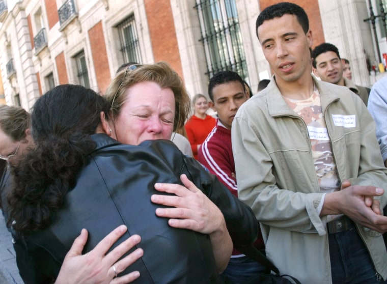 WOMAN IS EMBRACED BY IMMIGRANT DURING RALLY IN MADRID