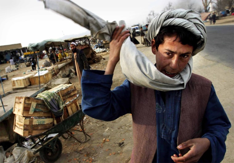 March 15, 2004 Yet another city once destroyed by the Taliban, Karabagh is trying to remend.&nbsp; With a recently opened medical clinic and its vibrant market area, the residents of this small area are attempting to rebuild what once was lost.&nbsp;&nbsp;&nbsp;&nbsp; During the weekly market day in Karabagh, a young man adjust his head wrap while setting up his cart of items.&nbsp; StaffPhoto imported to Merlin on&nbsp; Tue Mar 16 06:00:08 2004