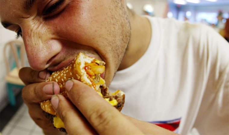 A McDonald's customer in Miami Beach, Fla., enjoys a double cheeseburger. McDonald's recently said it would phase out its supersized meal offerings. But many restaurant portions remain large, designed for a public that has shown its craving for value over taste, and a recent study highlighted the large portion of calories we get by  