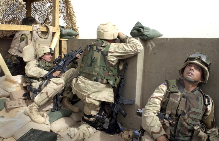 American soldiers take cover Sunday as the Spanish base comes under attack outside Kufa, north of Najaf, Iraq. 