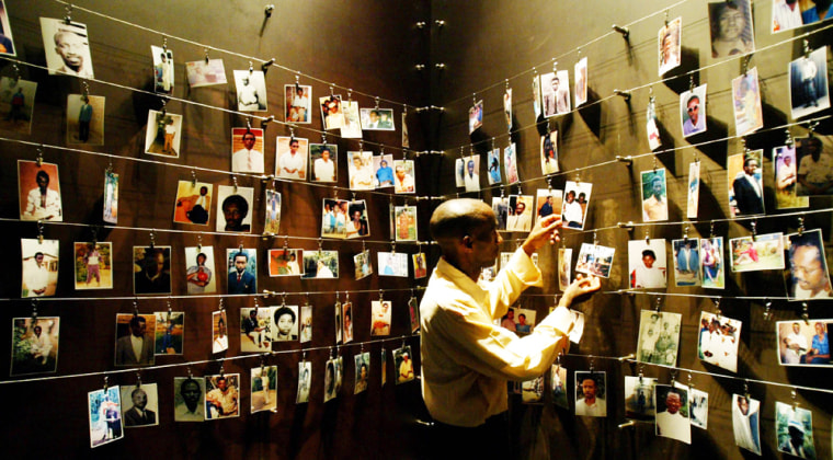 A RWANDAN GENOCIDE SURVIVOR LOOKS AT PICTURES INSIDE THE GISOZI MEMORIAL IN KIGALI