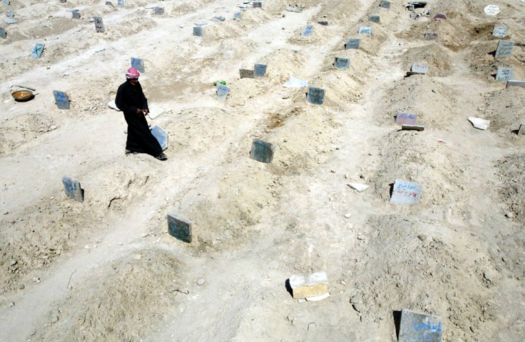 Iraqi Sunni Muslim, Mohammed Ahmad Ali, walks in a soccer field turned into a cemetery 11 April 2004 in the flashpoint town of Fallujah. Around 125 people are buried in this makeshift cemetery. 