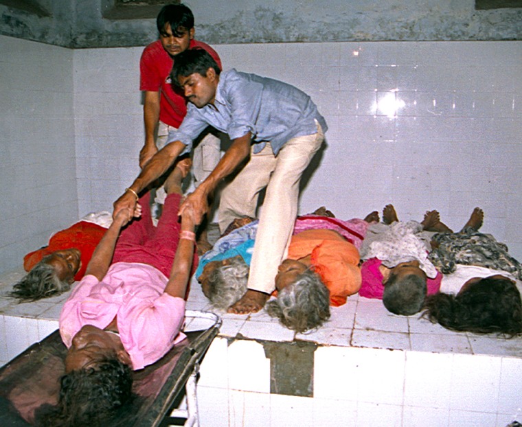 INDIAN PARAMEDICS LOAD DEAD BODIES INTO A HOSPITAL MORGUE AFTER A STAMPEDE IN LUCKNOW