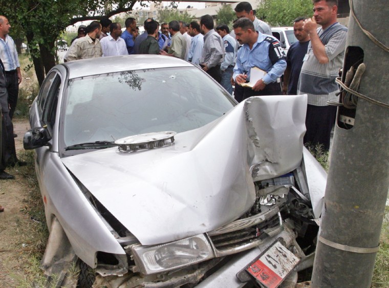 IRAQI POLICE STAND NEXT TO WRECKAGE OF IRANIAN DIPLOMATIC VEHICLE FOLLOWING ATTACK IN BAGHDAD