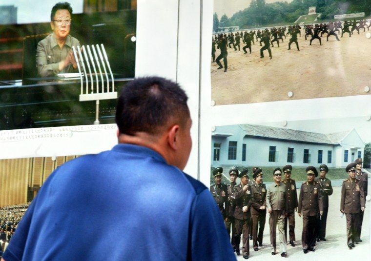 A passerby stops for a closer look at pictures of reclusive North Korean leader Kim Jong-Il posted outside the North korean embassy in Beijing, 19 April 2004. Kim, who arrived on an unannounced visit by special train, is to meet with Chinese President Hu Jintao for a summit expected to focus on the standoff over the Stalinist state's nuclear weapons programme.  AFP PHOTO/ Frederic J. BROWN