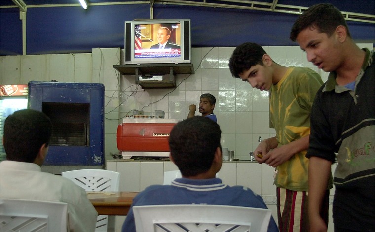 Iraqi men watch President Bush’s speech Wednesday in a cafe in downtown Baghdad.