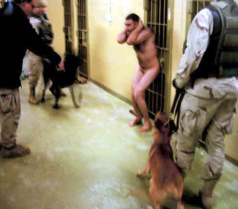 A naked Iraqi prisoner is surrounded by soldiers and dogs in Abu Ghraib prison in an undated photograph.