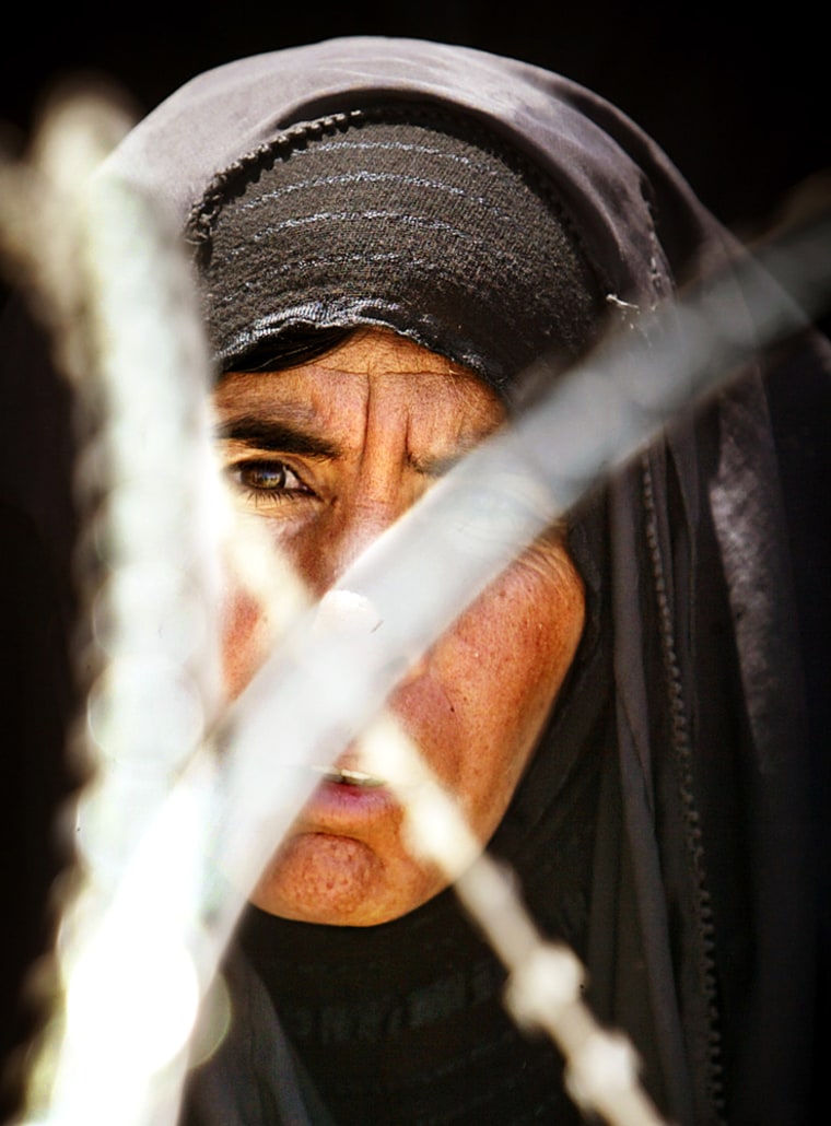 IRAQI WOMAN WAITS FOR INFORMATION ABOUT RELATIVE OUTSIDE ABU GHRAIB PRISON NEAR BAGHDAD