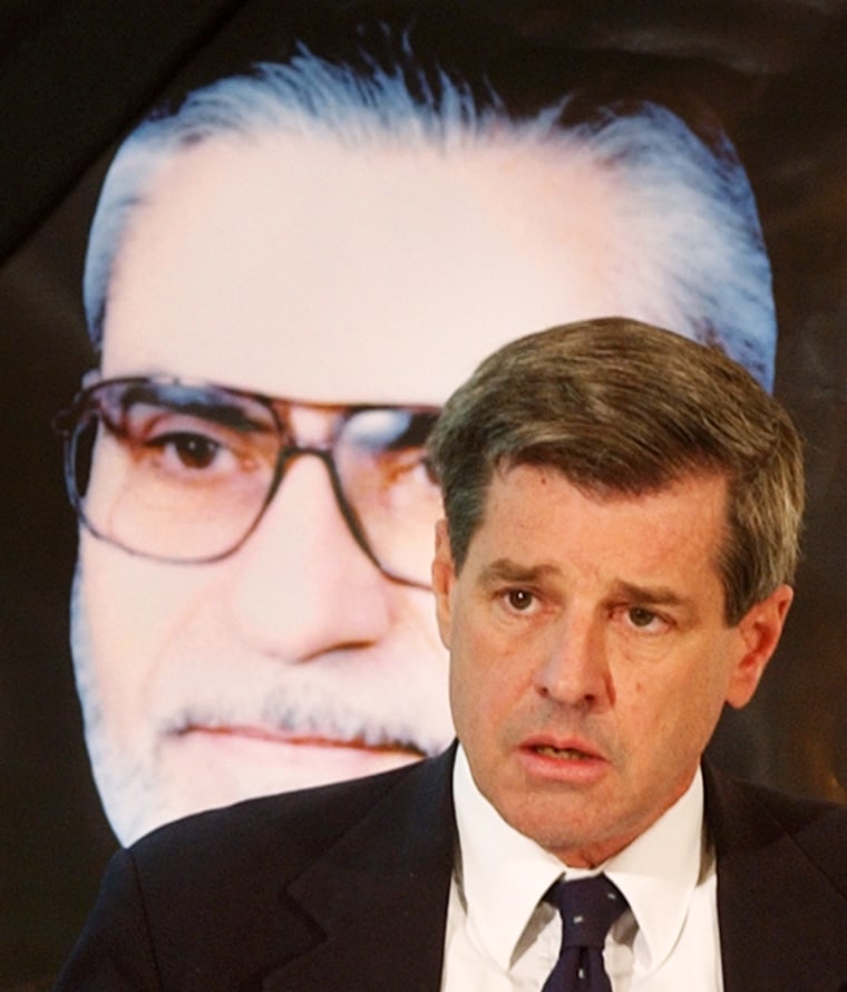 Top U.S. administrator in Iraq, L. Paul Bremer delivers a speech in front of a portrait of the chairman of the Iraqi Governing Council, Izzadine Saleem, during a funeral service inside the Green Zone in Baghdad, Iraq, Tuesday, May 18, 2004. Saleem was killed on Monday as his car waited at a checkpoint near the coalition headquarters in Baghdad. (AP Photo/Muhammed Muheisen)