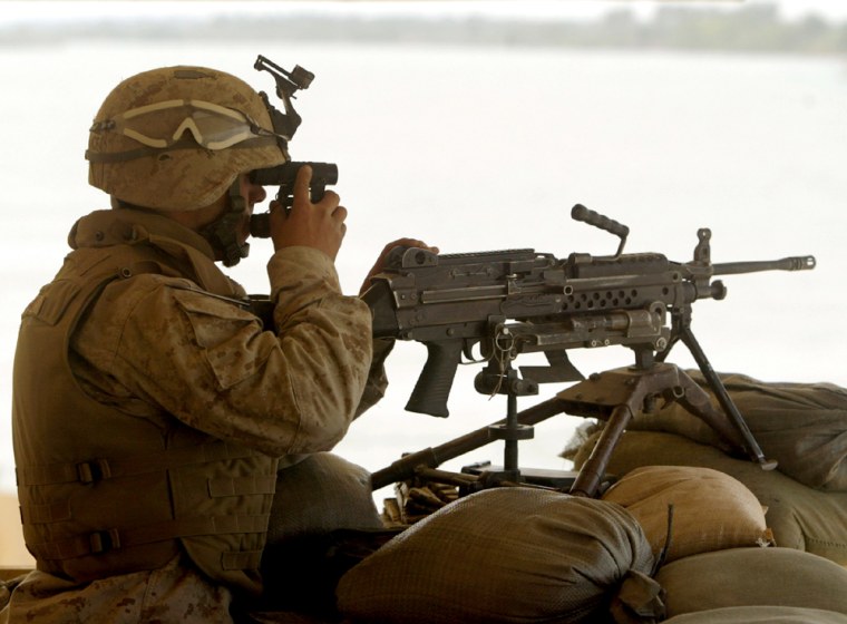 A U.S. MARINE IS SILHOUETTED BY EUPHRATES RIVER WHILE KEEPING SECURITY IN SAQLAWIYA IRAQ