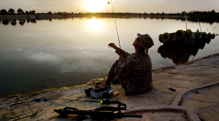 US SOLDIER FISHES NEAR FALLUJA ALONG THE EUPHRATES RIVER