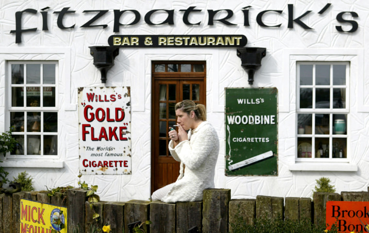 WOMAN SMOKES A CIGARETTE OUTSIDE COUNTY LOUTH BAR AFTER IRELAND'S SMOKING BAN CAME INTO FORCE