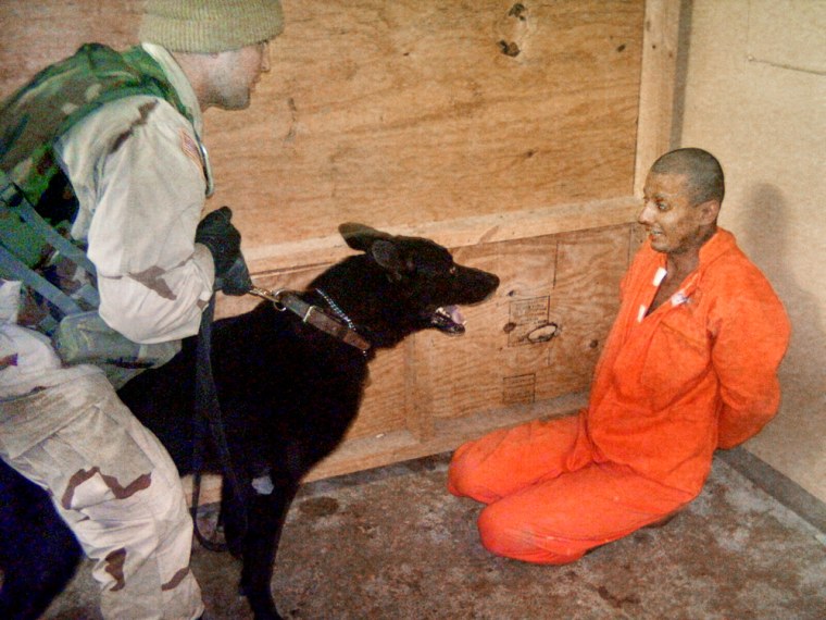 A U.S. soldier holds a dog in front an Iraqi detainee at Abu Ghraib prison, on the outskirts of Baghdad, in this undated photograph. 