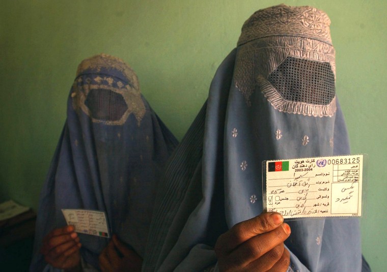 AFGHAN WOMEN HOLDS HER VOTER REGISTRATION CARDS