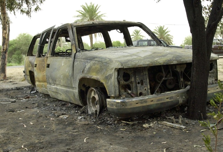 The burned out car belonging to Japanese journalists is seen in Al-Mahmudia, 40 km south of Baghdad, Iraq, Friday, May 28, 2004. Gunmen attacked the car carrying two Japanese journalists in Iraq late Thursday and set the vehicle on fire, Japan's Foreign Ministry said Friday. (AP Photo/Mohammed Uraibi)
