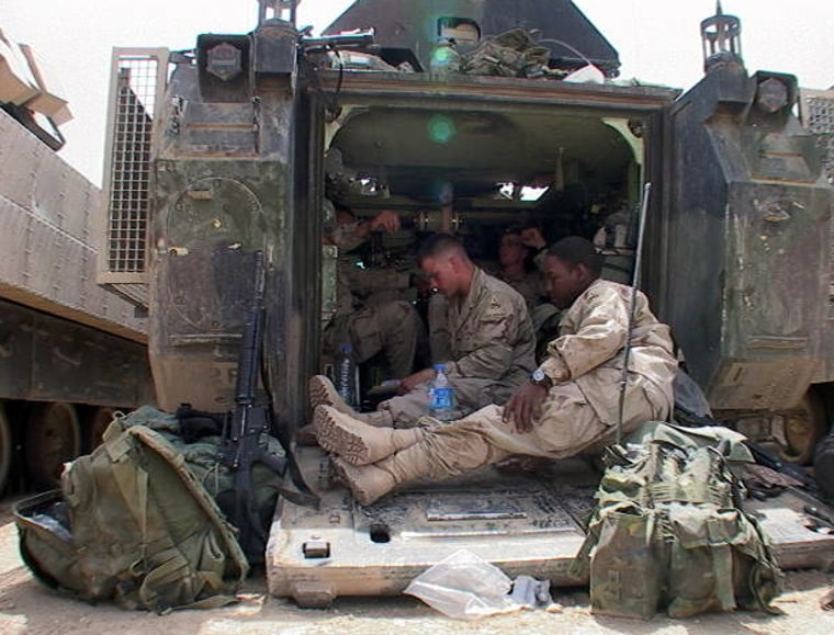Members of Bravo 1-36 of the 1 Armored Division take a break outside of Karbala.