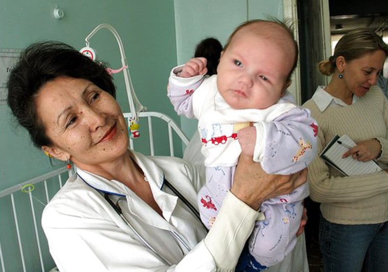 Rosa Varnakova, head of a clinic that houses 48 abandoned HIV-infected children in Irkutsk, Russia, holds up an infant born to an HIV-positive mother.