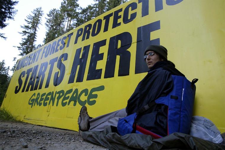 Greenpeace activist Jennifer Kirby sits Tuesday chained to a container placed on a forest road in southern Oregon.