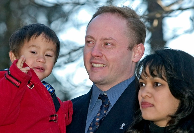 In a photo from April 2004, NASA astronaut Michael Fincke stands alongside his wife, Renita, and holds his son, Edward Chandra, during a photo opportunity at Russia's Star City cosmonaut training complex. The astronaut now has a daughter as well, named Tarali.