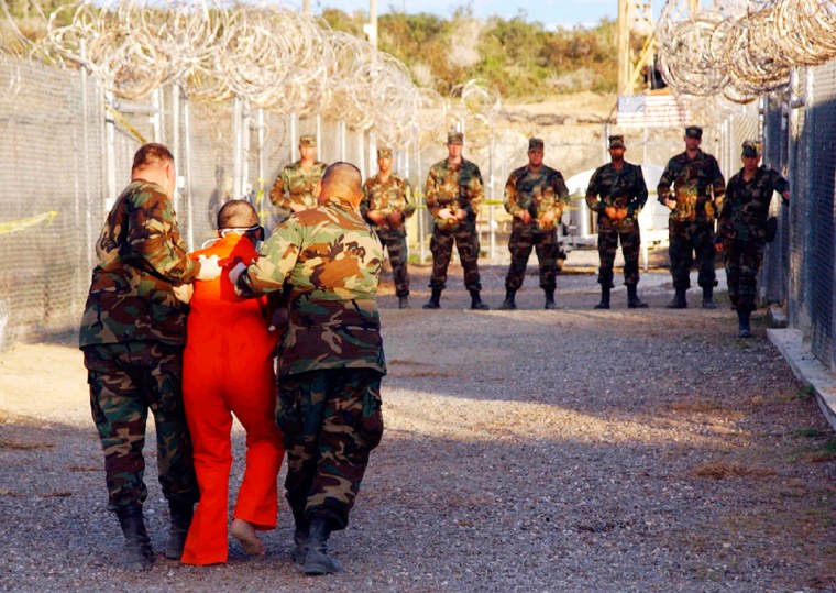 FILE PHOTO OF US MILITARY ESCORTING DETAINEE TO CELL AT XRAY NAVAL BASE