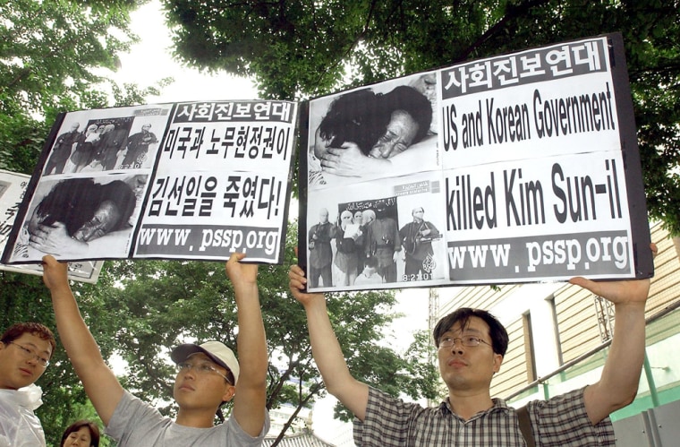 South Korean protesters hold placards du