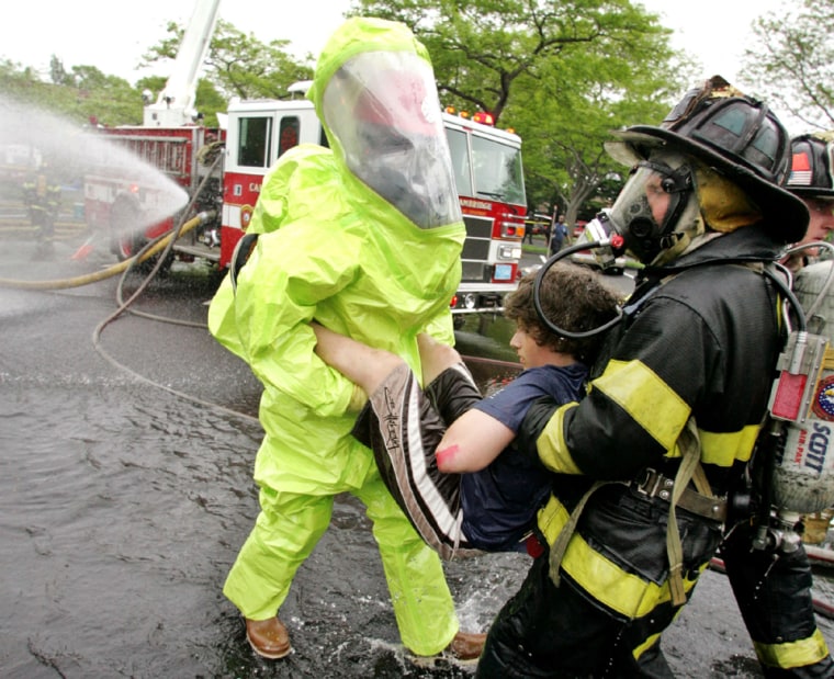 FIREFIGHTERS PRACTICE DECONTAMINATING SIMULATED VICTIMS DURING WMD ATTACK DRILL