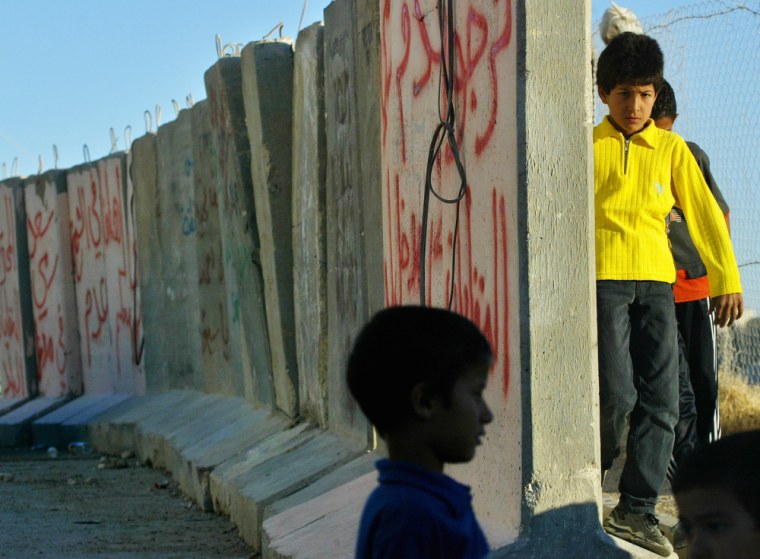 Palestinian children stand next to cement blocks, marking the path of Israel's separation barrier between the villages of Sheikh Sa'ad and Jabel Mukaber in east Jerusalem during a demonstration on June 23.