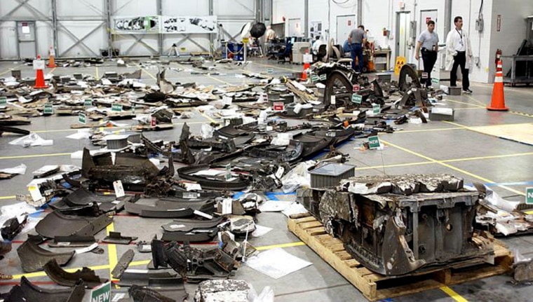 Pieces of Columbia debris cover the floor of a Kennedy Space Center hangar. Select pieces of the space plane have been released for loan to The Aerospace Corp. for testing and research.