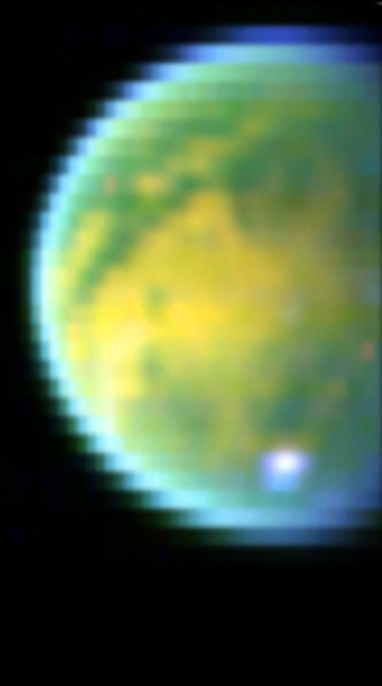 Three near-infrared images were combined to produce this rendition of Titan's surface, as seen by the Cassini spacecraft's camera. Yellow areas have high concentrations of hydrocarbons, while green areas are predominantly ice. The white spot toward the bottom is a methane cloud.