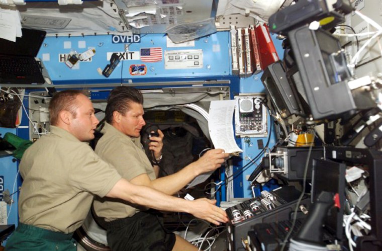 The current occupants of the international space station, NASA astronaut Mike Fincke and Russian commander Gennady Padalka, look over a checklist in the U.S.-built Destiny laboratory module during operations in May.