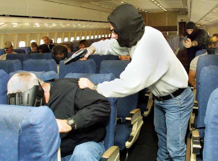 Federal air marshals are shown here performing tactical training inside a retired airliner. On the job, they must adhere to a dress code that some say makes them easily identifiable. 